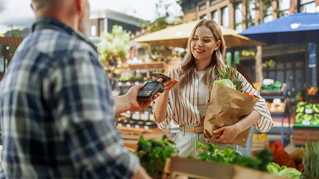 Woman paying for groceries with a credit card
