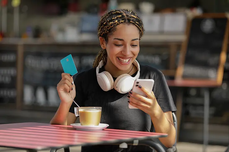 Woman holding credit card and phone
